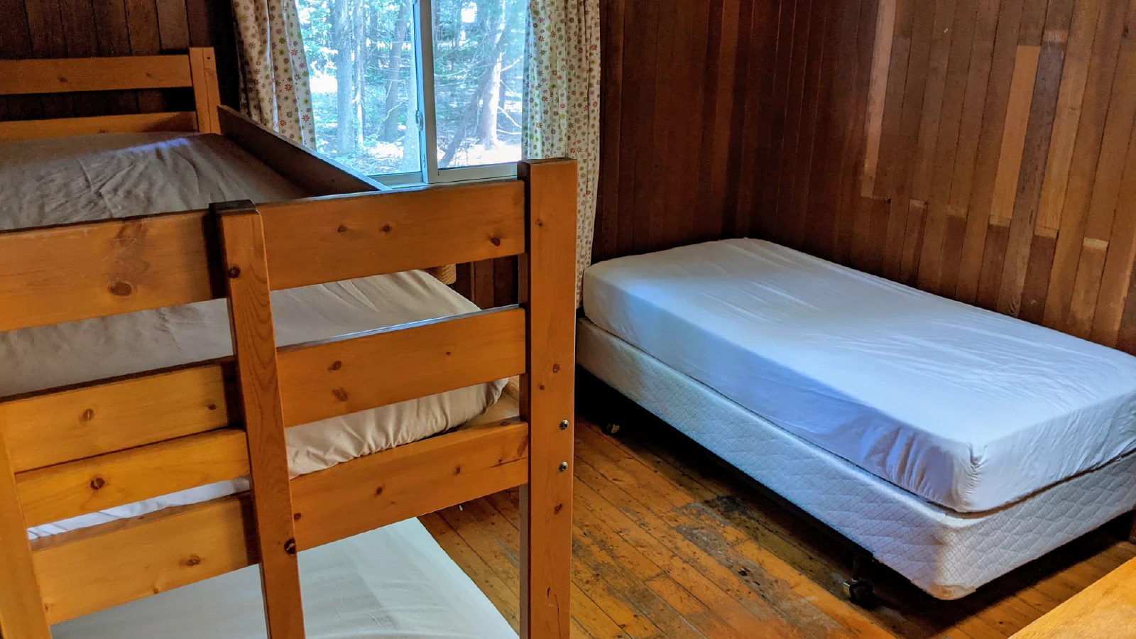 Pigeon Lake Resort Cottage Six, thrid bedroom with wooden bunk bed and single bed beside a window.